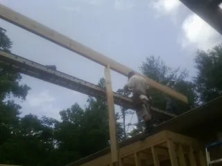 Carpenter setting a ridge beam over a new addition frame — Ice Dam Removal by Roofing Brothers in Kalamazoo