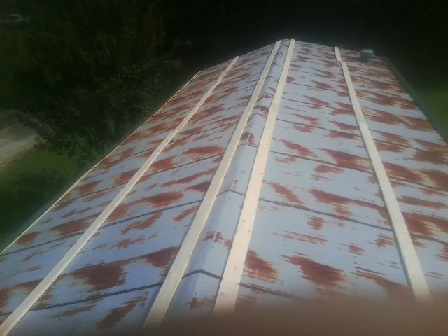 Rusted metal roof panels with new wood purlins before replacement — Storm Damage Roof Repair in Kalamazoo by Roofing Brothers