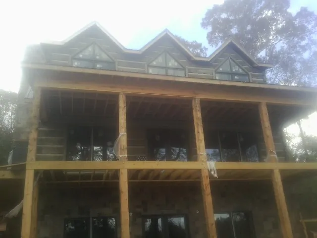Dormers and porch framing on a large log home under construction — Roof Coating work by our crew in Kalamazoo