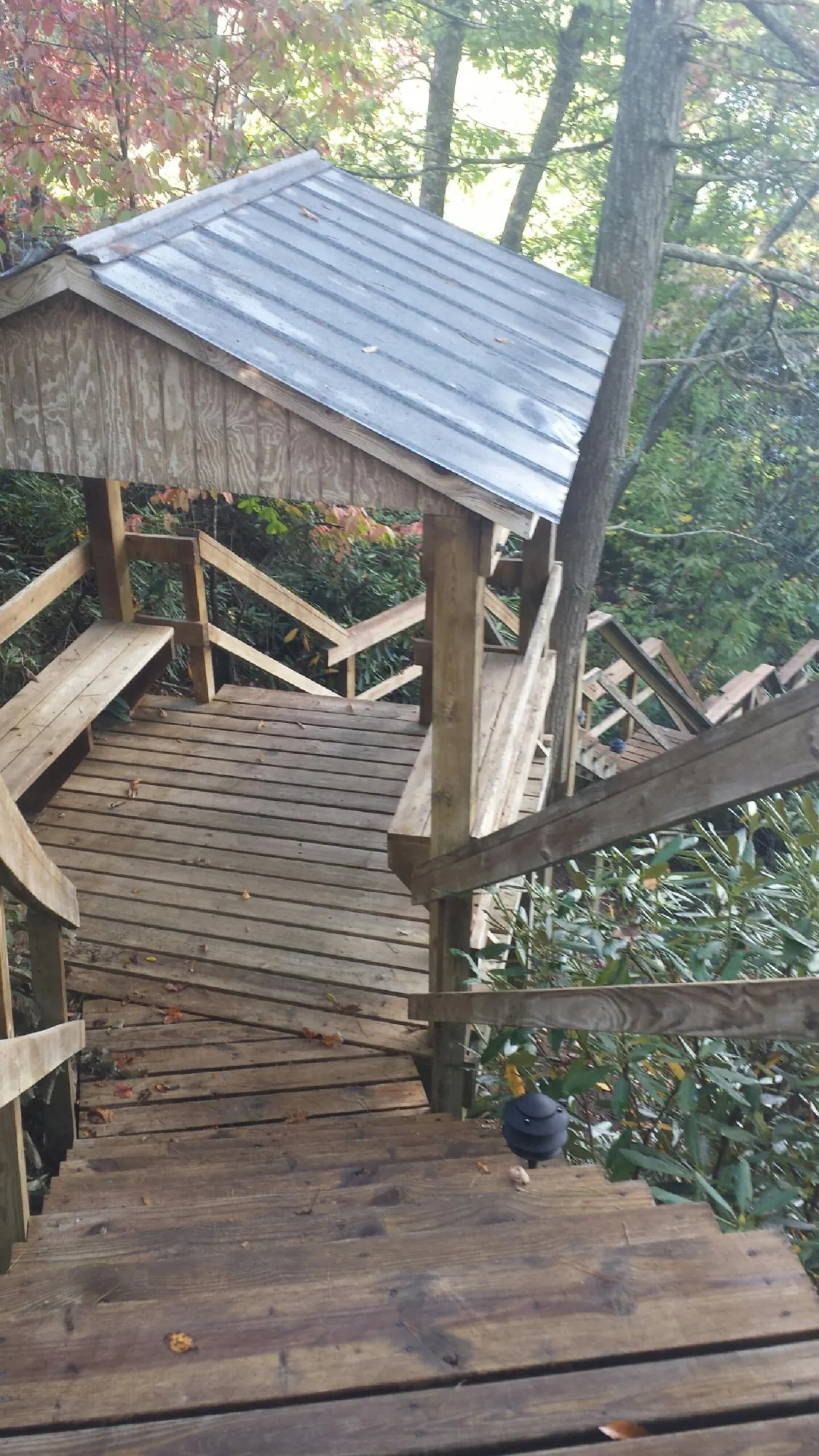 Metal roofed shelter over wooden steps on a wooded walkway — Skylight Repair & Installation work by our crew in Kalamazoo