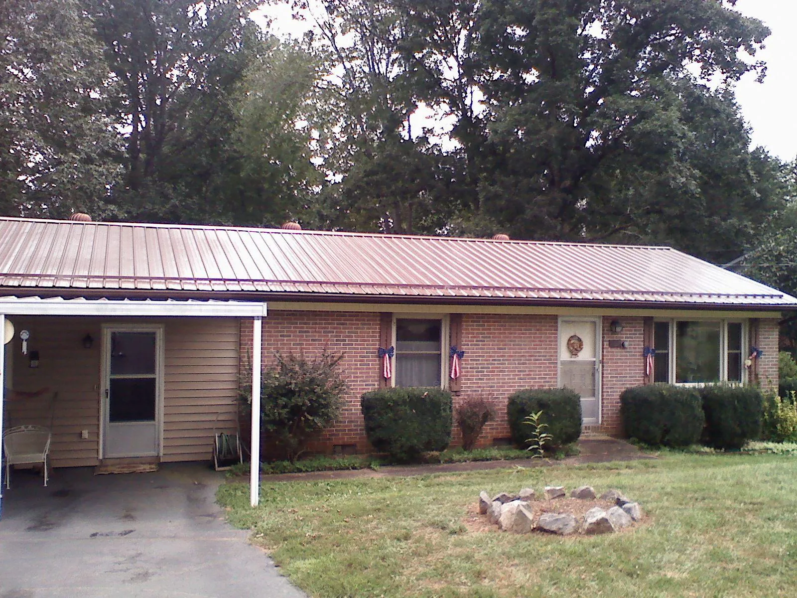 Bronze metal roof and carport on a brick ranch home — Roof Repair work by our crew in Kalamazoo