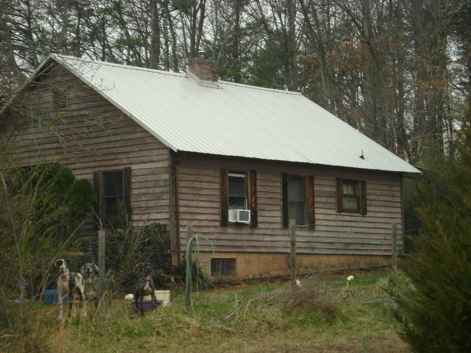 White metal roof on an old wood sided farmhouse, from a Metal Roof Installation job in Kalamazoo